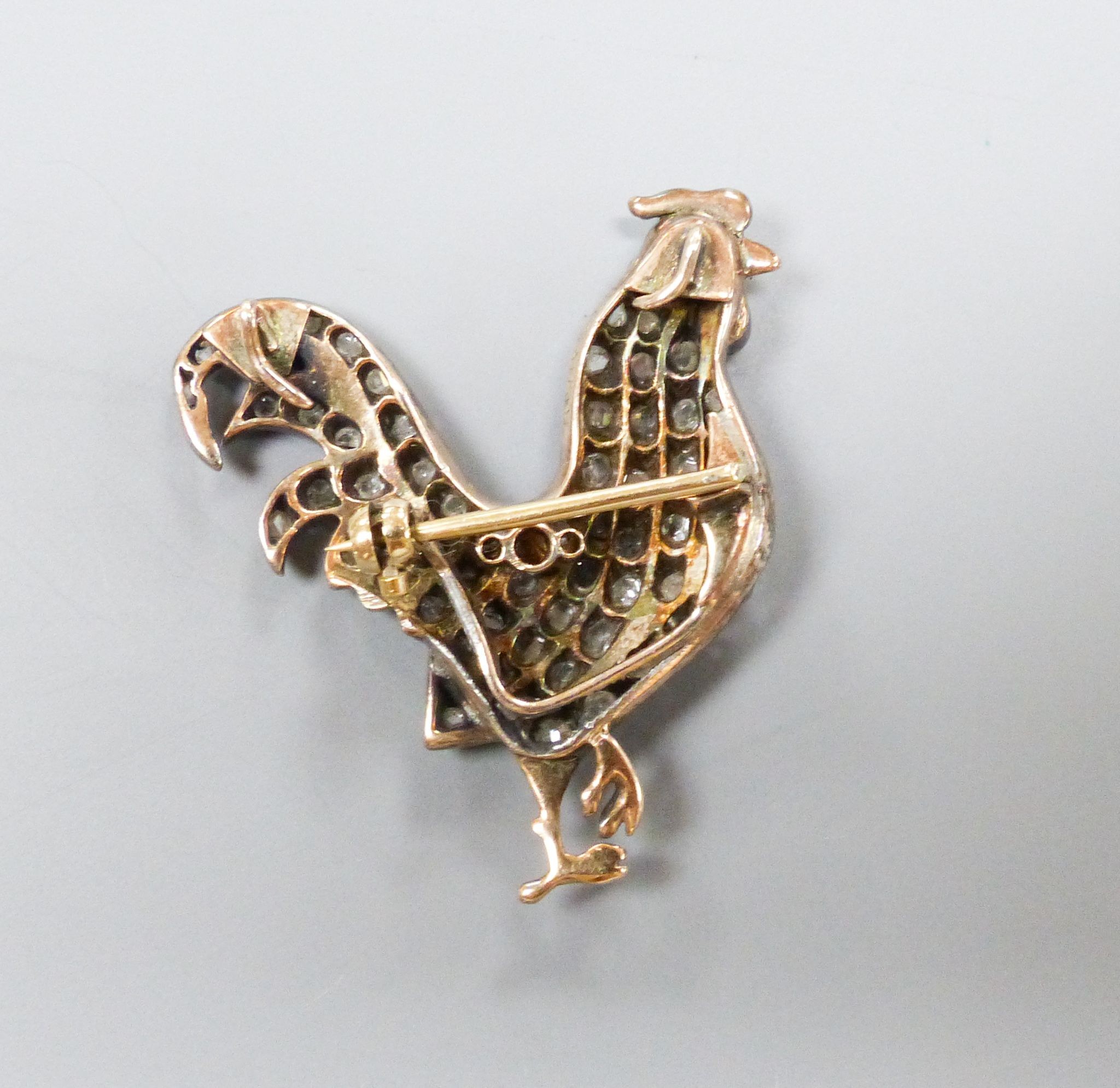 A Victorian yellow and white metal, enamel and rose cut diamond set cockerel pendant, now with later brooch attachment, enamel a.f, 37mm, gross weight 8.8 grams.